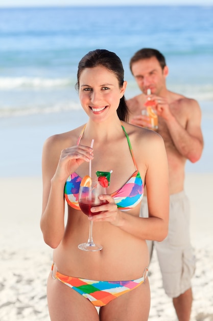 Pareja bebiendo un cóctel en la playa