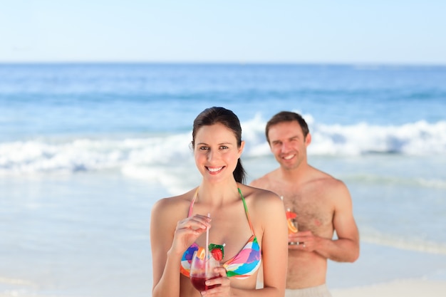 Pareja bebiendo un cóctel en la playa