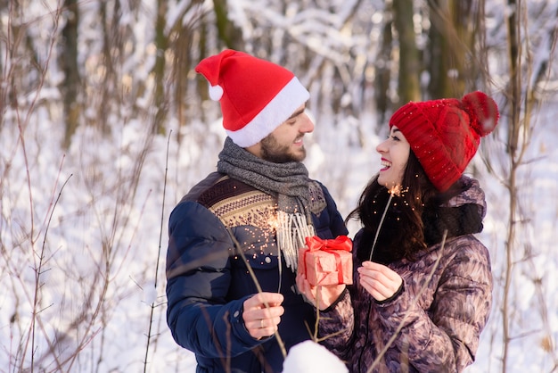 Foto pareja con bengals y regalo sonríe el uno al otro