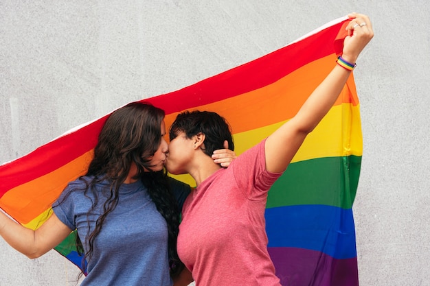 Pareja besándose con bandera de orgullo. Concepto LGBT