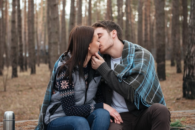 Pareja besándose en el bosque