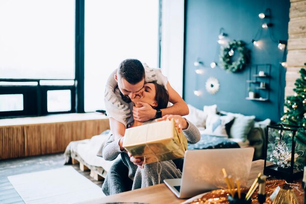 Pareja besándose en casa el día de Navidad