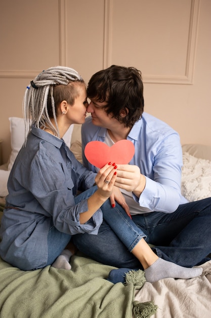 Pareja besándose con corazón rojo San Valentín en las manos.