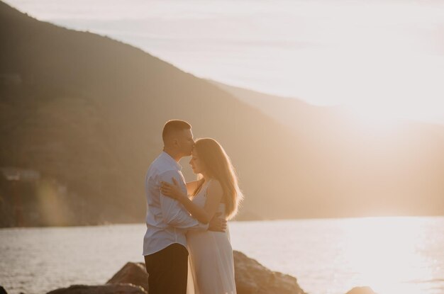 Pareja besándose en una roca junto al mar