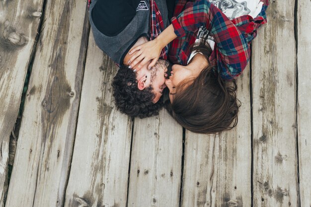 Pareja besándose en un suelo de madera