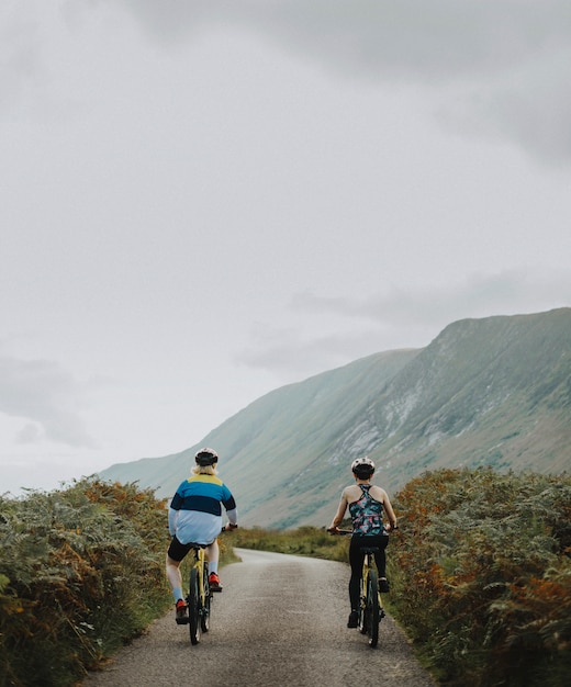 Pareja en bicicleta por una carretera en las tierras altas de Escocia