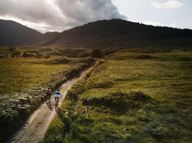 Pareja en bicicleta por una carretera en las tierras altas de Escocia