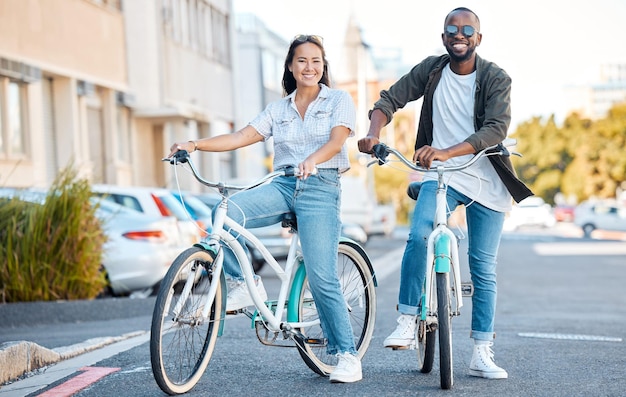 Pareja en bicicleta y viaje con un hombre negro y una mujer asiática en bicicleta en la ciudad para hacer turismo o aventura Huella de carbono en bicicleta y amor con un hombre y una mujer saliendo juntos en un pueblo urbano