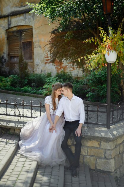 Pareja de boda de lujo abrazando abrazos y besos en luz soleada. hermosa novia y novio con estilo en un momento emocional tierno y sensual.