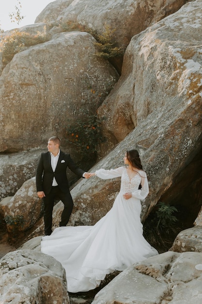 Pareja de boda. De pie cara a cara con las verdes colinas de fondo.