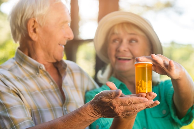 Pareja con bote de pastillas sonriente senior hombre y mujer droga con vitaminas y minerales restaurar su él