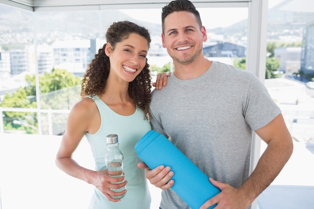 Pareja con botella de agua y colchoneta