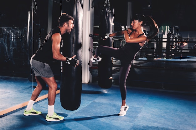 Foto pareja boxeando en gimnasio