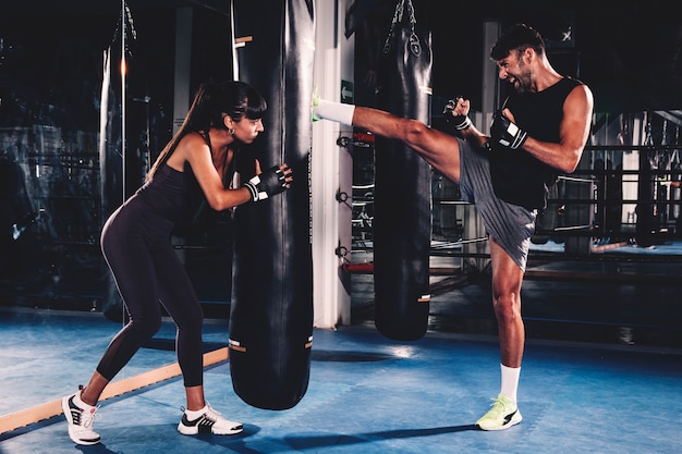 Foto pareja boxeando en gimnasio