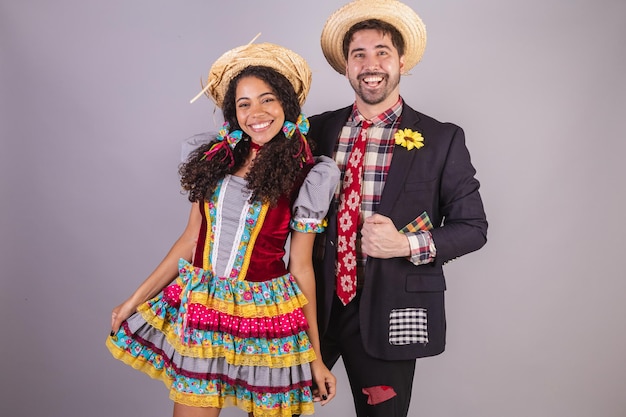 Foto pareja brasileña vistiendo ropa de fiesta de junio fraternización en nombre de sao joao arraial abrazado