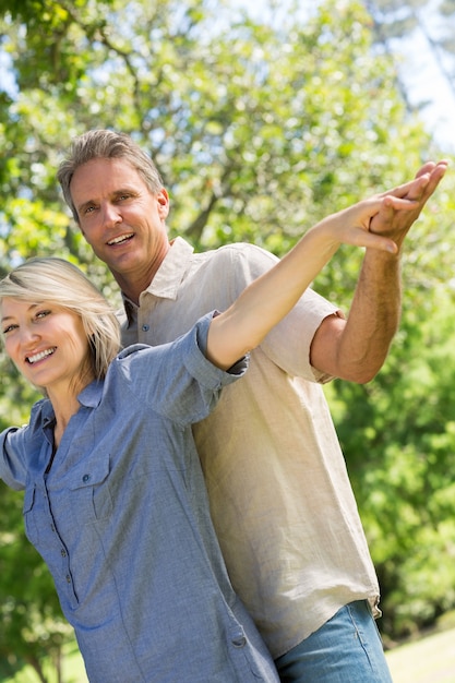 Foto pareja con los brazos extendidos en el parque