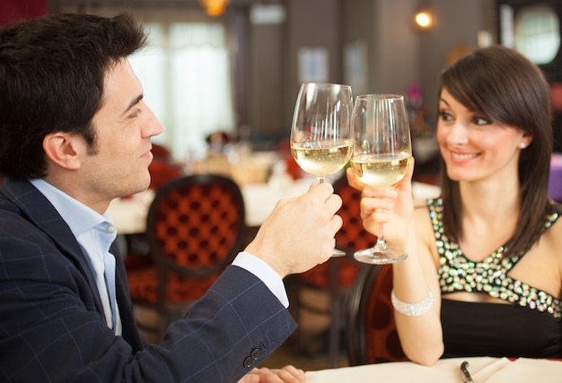 Pareja brindando copas en un restaurante