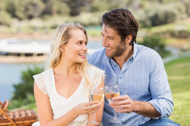 Pareja brindando con vaso de vino blanco