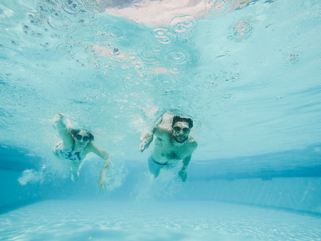 Foto pareja buceando en piscina