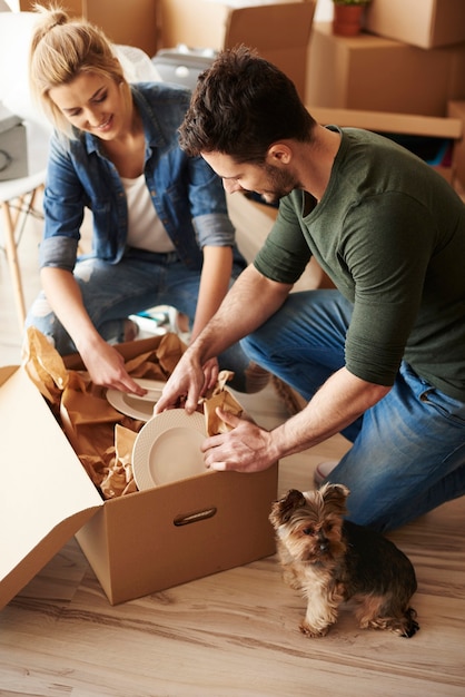 Pareja con caja de platos y perro