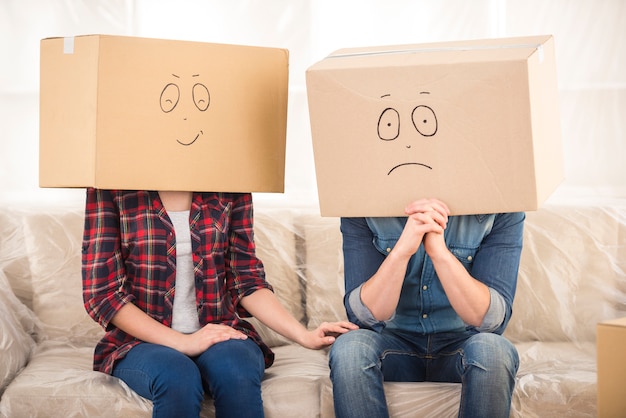 Pareja con cajas de cartón en sus cabezas.