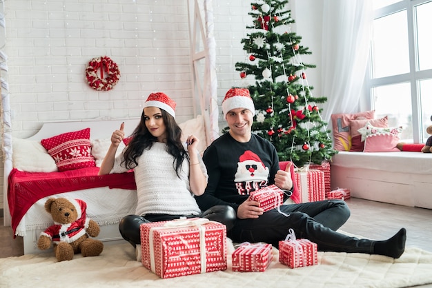 Pareja con cajas de regalo sentados en el suelo