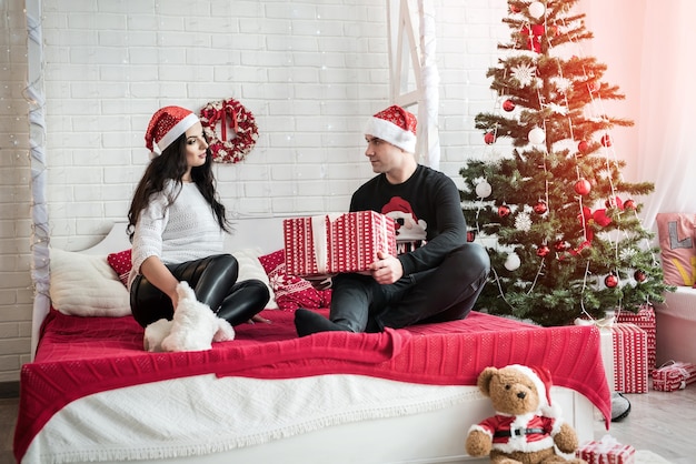 Pareja con cajas de regalo sentados en el suelo