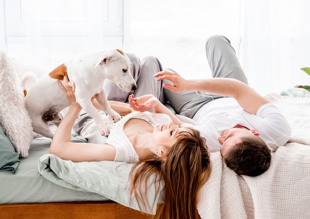 Pareja, en la cama, con, perro