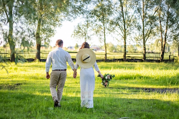 La pareja camina por el campo Se toman de la mano El velo se disipa En las manos de un ramo