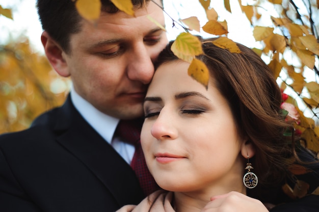 Pareja camina en el parque. Abrazo romántico de los recién casados.