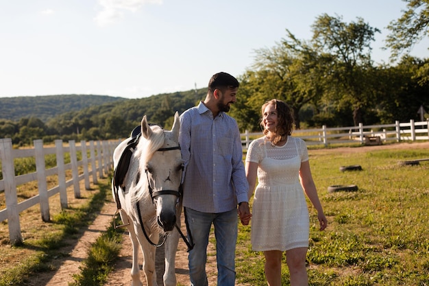 Pareja camina en el rancho durante el día de verano