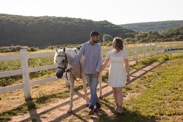 Pareja camina en el rancho durante el día de verano