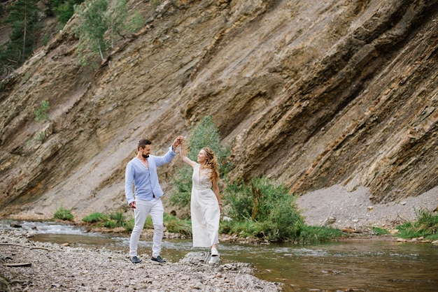 La pareja camina entre las rocas del río en el parque nacional.