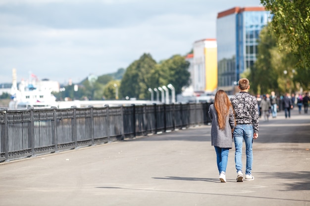 Pareja camina por el terraplén de la ciudad