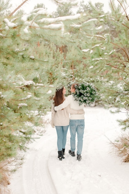 Pareja caminando en el bosque nevado