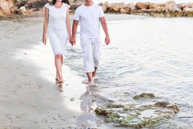 Pareja caminando juntos por la playa