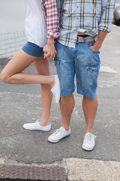 Pareja en camisas de cuadros y denim cogidos de la mano