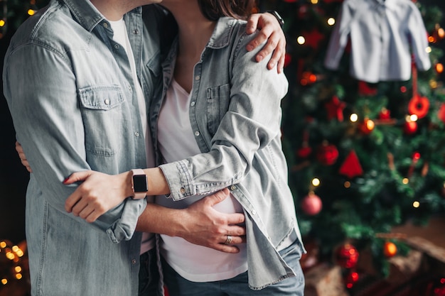 Pareja en camisas grises esperando un bebé para el año nuevo