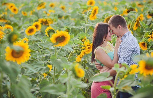 Foto pareja en un campo de girasoles