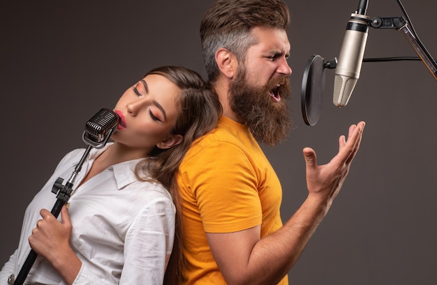 Pareja cantando cantantes de karaoke hombre y mujer joven cantando con micrófono de música