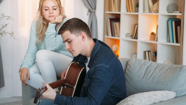 Pareja cantando ocio romántico música hobby hombre feliz enamorado disfrutando juntos de la actividad en el interior