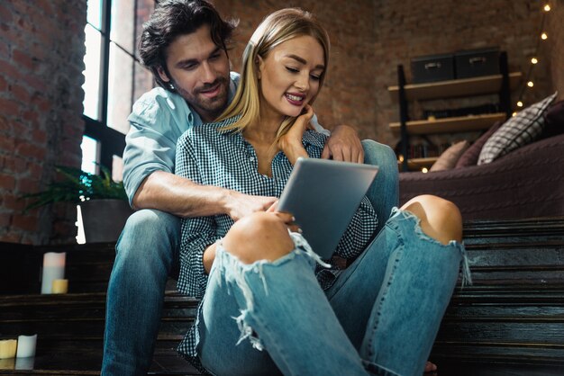 Pareja en casa mirando tableta