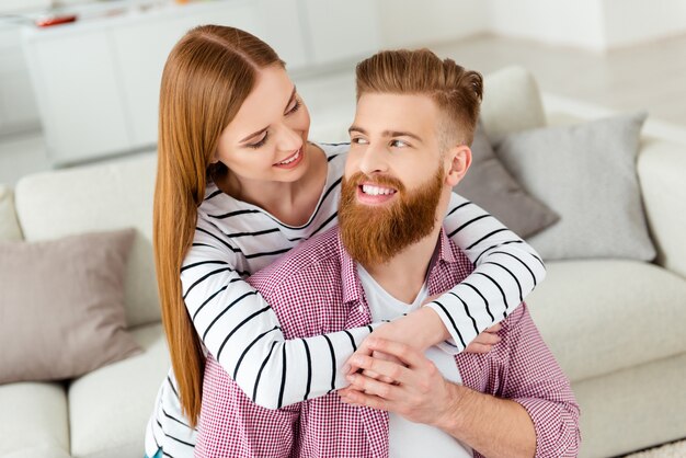 Pareja, en casa, en, sofá, se abrazar