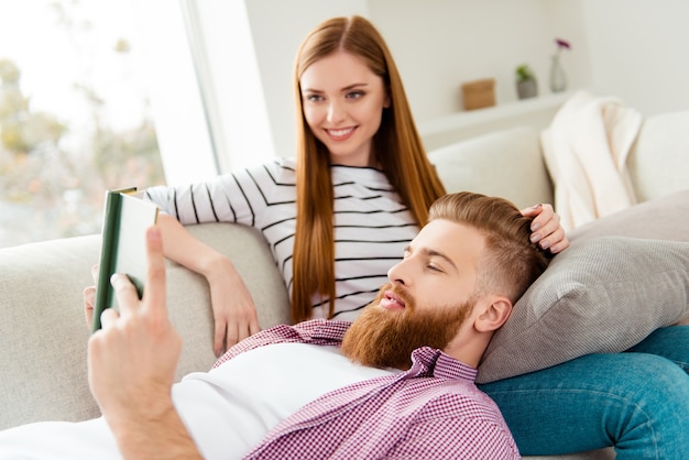 Pareja, en casa, en, sofá, libro de lectura