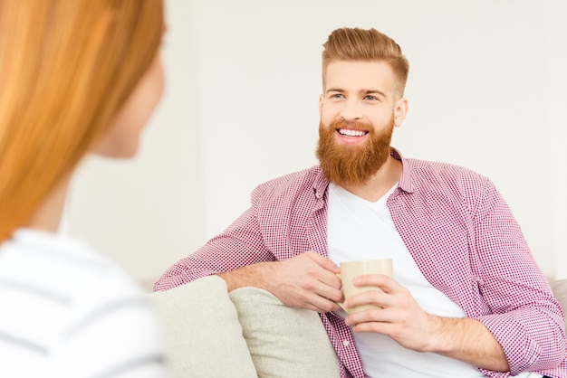 Pareja en casa en el sofá tomando café