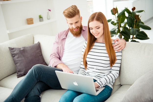 Pareja, en casa, en, sofá, usar la computadora portátil