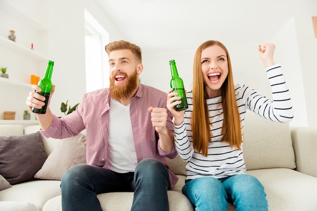 Pareja en casa viendo la televisión juntos y tomando cerveza