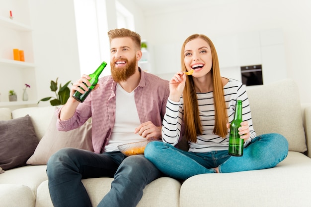 Pareja en casa viendo la televisión juntos y tomando cerveza