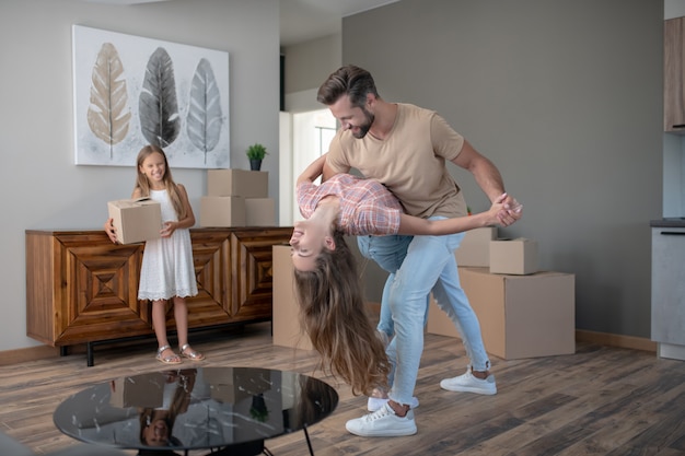 Pareja casada bailando en una casa nueva