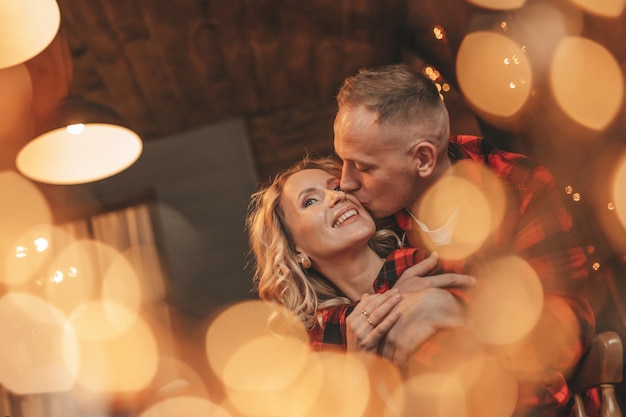 Una pareja casada feliz y auténtica pasa tiempo a solas en la cabaña decorada con Navidad.